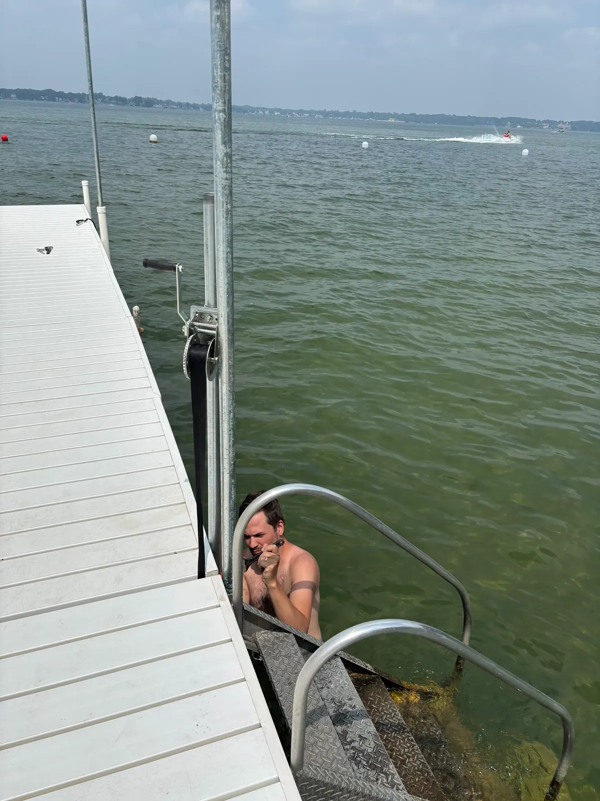 Installer working from the water beside DockShade post and furling hardware
